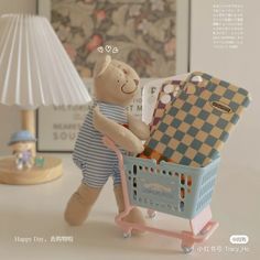 a teddy bear sitting in a shopping cart next to a lamp and other items on a table