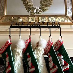 christmas stockings hanging from a rack in front of a mirror with a wreath on it