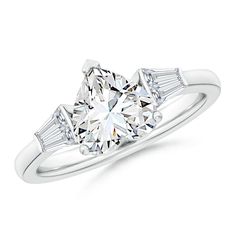 a three stone diamond ring with baguetts on the shoulders and side stones in white gold