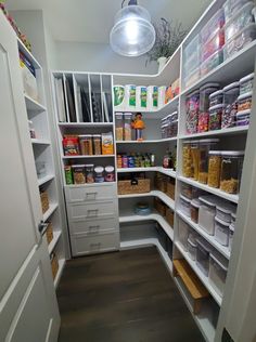 an organized pantry with white shelving and lots of food in the bins on shelves