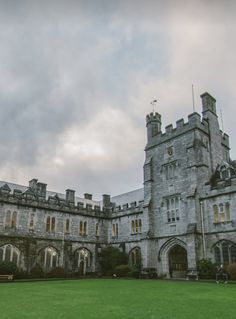 an old castle with a green lawn in front