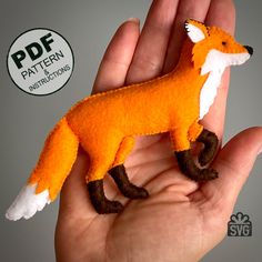 a hand is holding a small felt fox