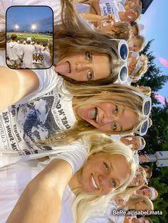 three women are taking a selfie in front of a group of other people at a sporting event