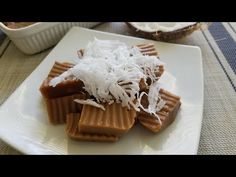 some kind of food on a plate with coconut flakes and other foods in the background