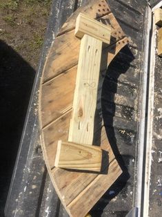 a boat made out of wooden planks on top of a metal table next to another boat