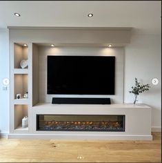 an entertainment center with a flat screen tv and built - in fire place on the wall