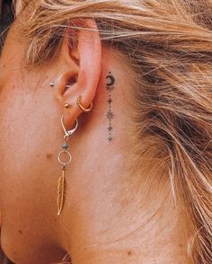 a close up of a person's ear with a tattoo on her left side