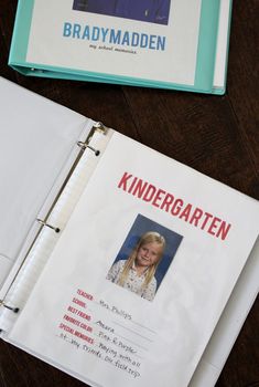 an open binder on top of a desk next to a folder with a photo