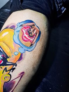 a person with a tattoo on their leg has a doughnut in the shape of a man's head