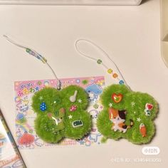 two green ear buds with animals on them