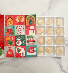 an open box of christmas cookies on a table