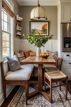 a kitchen table with two chairs and a vase filled with fruit on top of it