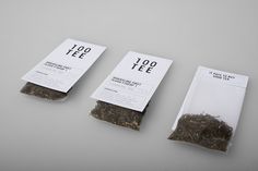 three bags of tea sitting on top of a table next to each other with labels