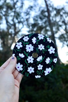 a person holding up a black and white flowered button