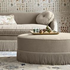 a couch and ottoman in front of a wall with circles on the wall behind it