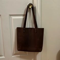 Handmade Leather Tote Bag Features An Interior Zipper Pocket. Reinforced Bottom And Twin Handles For Better Durability. Simple, Elegant, And Easy To Carry. Beautiful Brown Leather Bag Perfect For Travel Or Everyday Use. Fits A Laptop Perfectly, Or Whatever You Need For A Day Trip. Worn A Few Times; The Scratches Shown Are Typical For This Type Of Material (Most Were Present When Purchased). It’s So Well-Made And The Color Is Gorgeous, It Just Doesn’t Really Match My Style, So I’d Love To See It Go To Someone Who Will Wear It Well! Classic Handmade Bags For Daily Use, Classic Handmade Bag For Daily Use, Handmade Leather Shopping Bags, Handmade Satchel With Double Handle For Everyday Use, Handmade Leather Bags For Shopping, Handmade Double Handle Satchel For Everyday Use, Brown Long Handle Bucket Bag For Daily Use, Handmade Brown Bag For Everyday Use, Everyday Leather Rectangular Bag