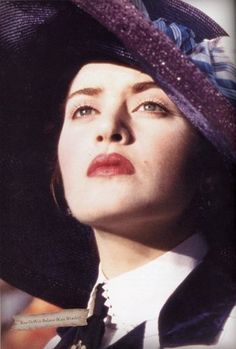 a woman wearing a purple hat with sequins on it's brim