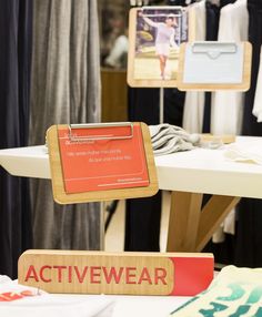 there is a sign that says active wear on the table next to other clothing items