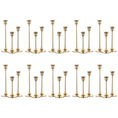 a set of twelve brass candlesticks in various sizes and shapes, all lined up against one another