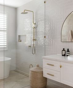 a bathroom with white tile and gold accents