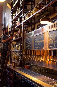 a man standing on a ladder in front of a bar