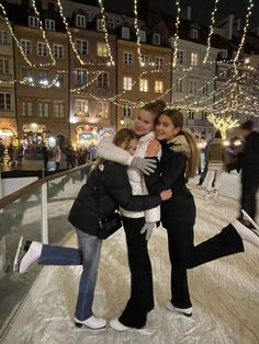 two women hugging each other on an ice rink at night with christmas lights in the background