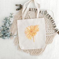 "This trendy sunflower canvas tote bag is ready to hold your towel and head to the beach or carry your book and sweater to your favorite coffee shop. This is versatile as a beach bag, school bag, grocery bag, or errand bag.  Details: - One size: 15\" x 16\"  - 20\" handle length  - 100% cotton canvas tote - Lightweight and compact - Print is on one side, the other side is blank  - The reinforced handle stitching creates a reliable bag for practicality and durability Care instructions:  - Pretrea Handmade Eco-friendly Canvas Bag For Summer, Cotton Beach Bag For Daily Use In Spring, Spring Beige Cotton Beach Bag, Summer Beige Cotton Canvas Bag, Everyday Summer Yellow Canvas Bag, Summer Canvas Gift Bag, Yellow Cotton Canvas Gift Bag, Yellow Cotton Tote Canvas Bag, Yellow Cotton Canvas Tote Bag