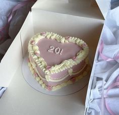 a pink heart shaped cake in a box