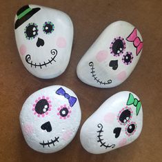 four painted rocks sitting on top of a table