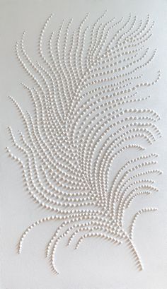 an intricately designed piece of art made out of white beads on a white surface