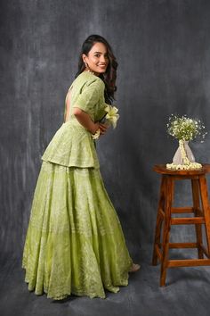 Twirl in style and elegance this festive season with this alluring pista green pure silk organza peplum lehenga from Pure Elegance featuring intricate tonal thread embroidery and slight shimmer work. Made with premium quality pure silk organza fabric, this set contains a choli, a lehenga. Pair it up with statement jewellery to complete your lookbook this season. Style this set with a pair of diamond earrings and solid pumps to finish the look from Pure Elegance. Disclaimer: The actual product ma Anarkali Peplum Sets With Chikankari Embroidery, Peplum Sharara With Chikankari Embroidery For Festive, Festive Peplum Sharara With Chikankari Embroidery, Green Peplum Festive Dress, Festive Green Peplum Dress, Designer Pista Green Sets With Cutdana, Designer Wear Peplum Sharara With Chikankari Embroidery, Eid Peplum Dress With Chikankari Embroidery, Designer Sharara With Chikankari Embroidery