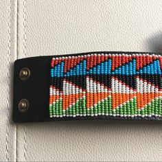 a black leather keychain with colorful beading on it