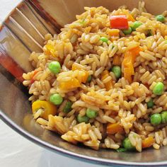 a bowl filled with rice, peas and carrots