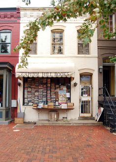 an old book store on the corner of a brick street in front of two buildings