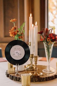 a table with candles, plates and flowers on it