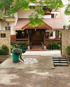 a woman is washing her hands in front of a house