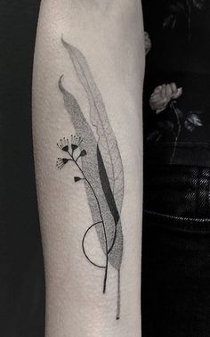 a black and white photo of a feather tattoo on the right arm, with an abstract design