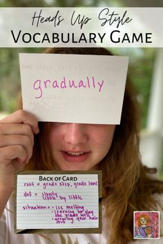 a girl holding up a card with the words, back of card reads'heads up style vocabulaary game '