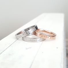 three wedding rings with names engraved on them