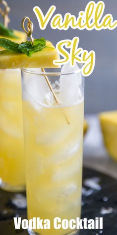 two glasses filled with lemonade and garnish on top of a table next to sliced