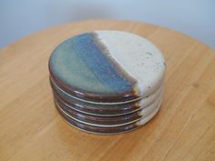 a stack of ceramic coasters sitting on top of a wooden table