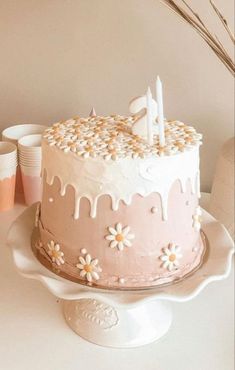 a pink cake with white icing and flowers on it