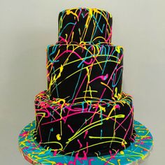 a three tiered cake with neon paint sprinkles