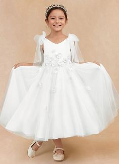 Minia is a charming flower girl matte satin A-line dress that features delicate tulle fabric that creates a whimsical, fun, and flowy effect. Her V-neckline is adorned with bow details on the shoulders that add an extra touch of sweetness and charm. The full A-line silhouette ensures a graceful and twirl-worthy appearance. Satin Flower Girl Dresses, Burgundy Flower Girl Dress, Tea Length Flower Girl Dress, Tea Length Tulle, Satin Flower Girl Dress, Maternity Bridesmaid Dresses, Ivory Flower Girl, Military Ball Dresses, Special Event Dresses