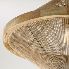 a close up of a light fixture made out of wood and wicker with an intricate design