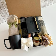 an open book, coffee mug, and other items in a box