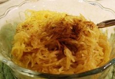 a glass bowl filled with shredded cheese on top of a green cloth covered tablecloth