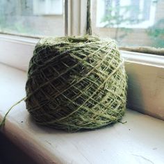 a ball of yarn sitting on top of a window sill