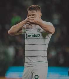 a soccer player covers his face with his hands