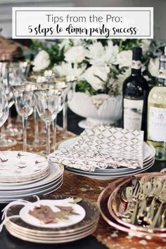 the table is set with wine glasses, plates and utensils for an elegant dinner party